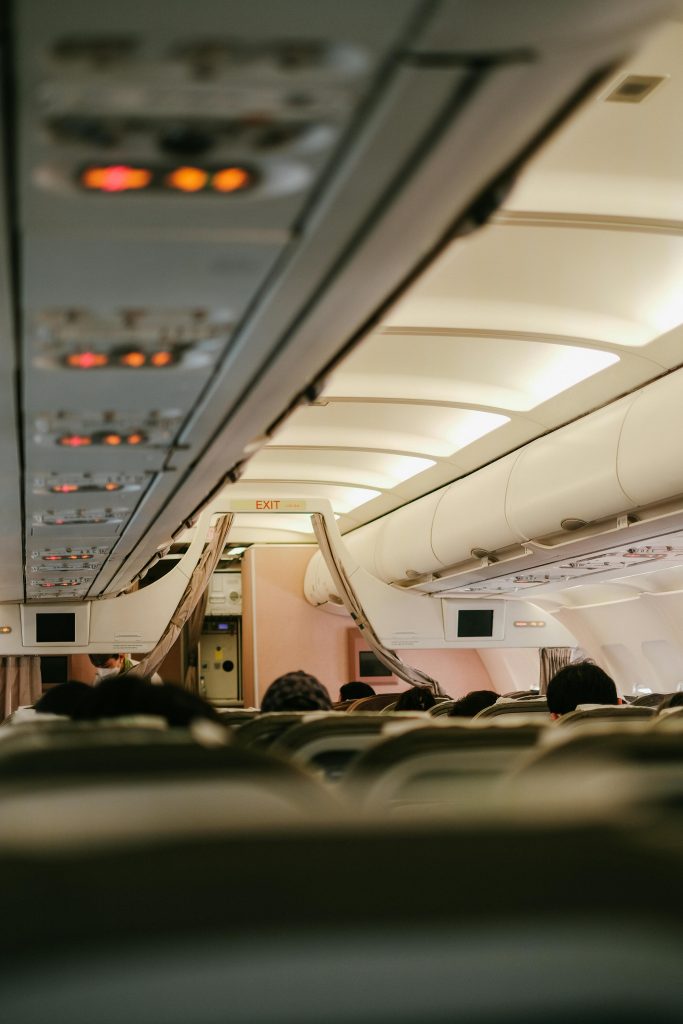 View of an airplane cabin interior with passengers seated, showcasing travel ambiance.